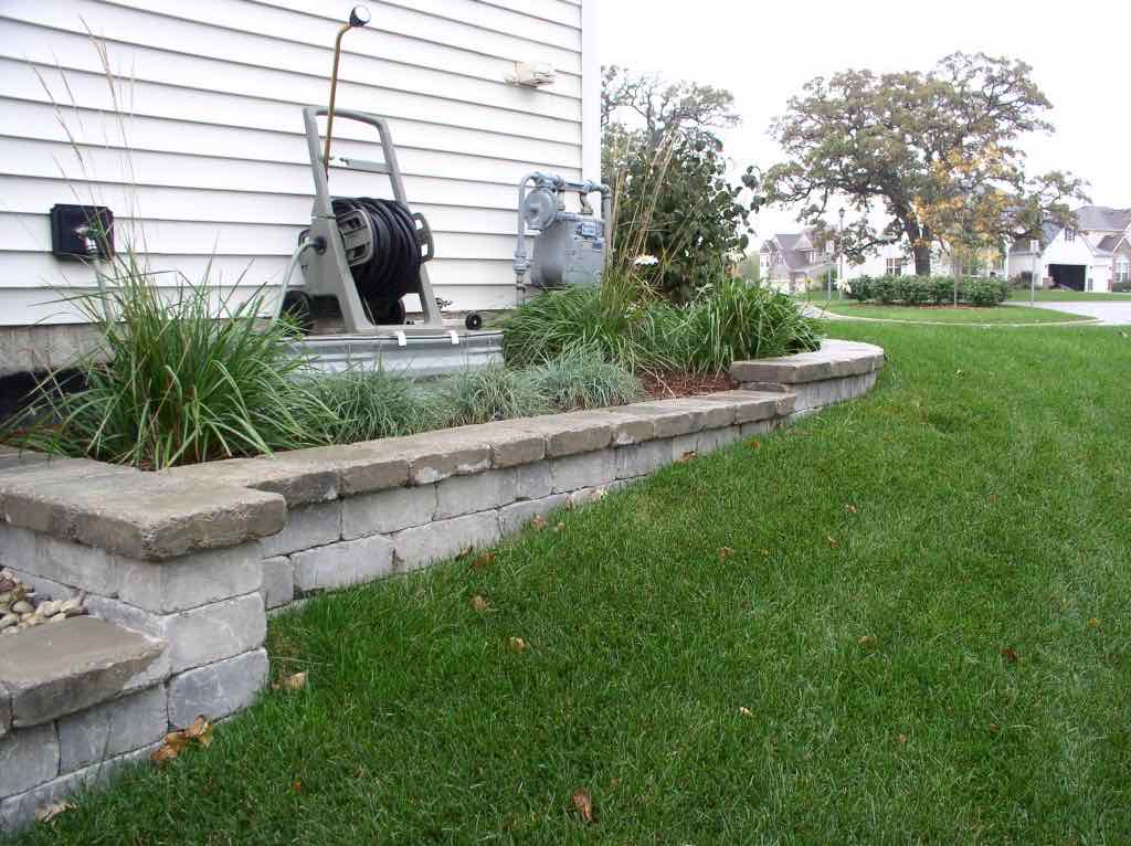 Stone edged garden bed along a home's exterior wall