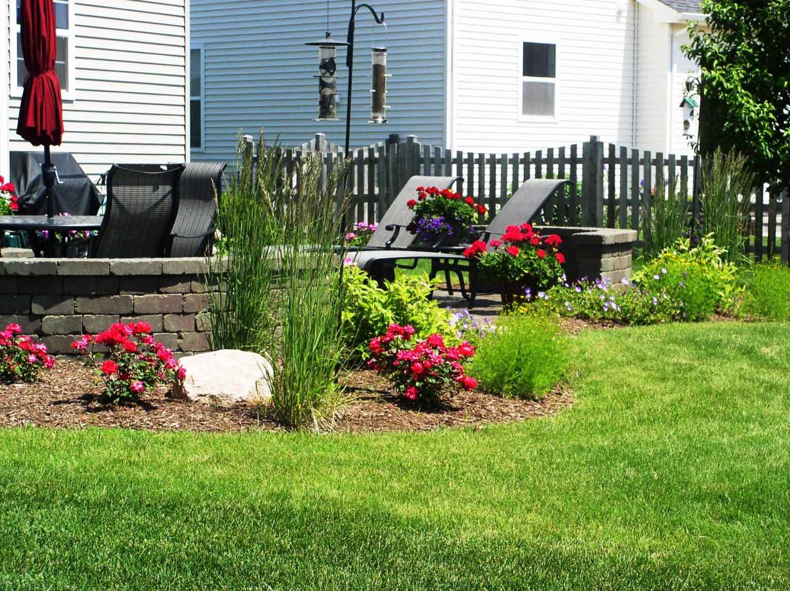 Planting bed with roses and ornamental grasses along a patio