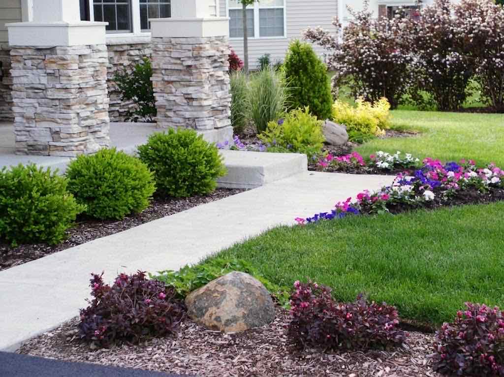 Planting bed with shrubs and flowers along a front walkway