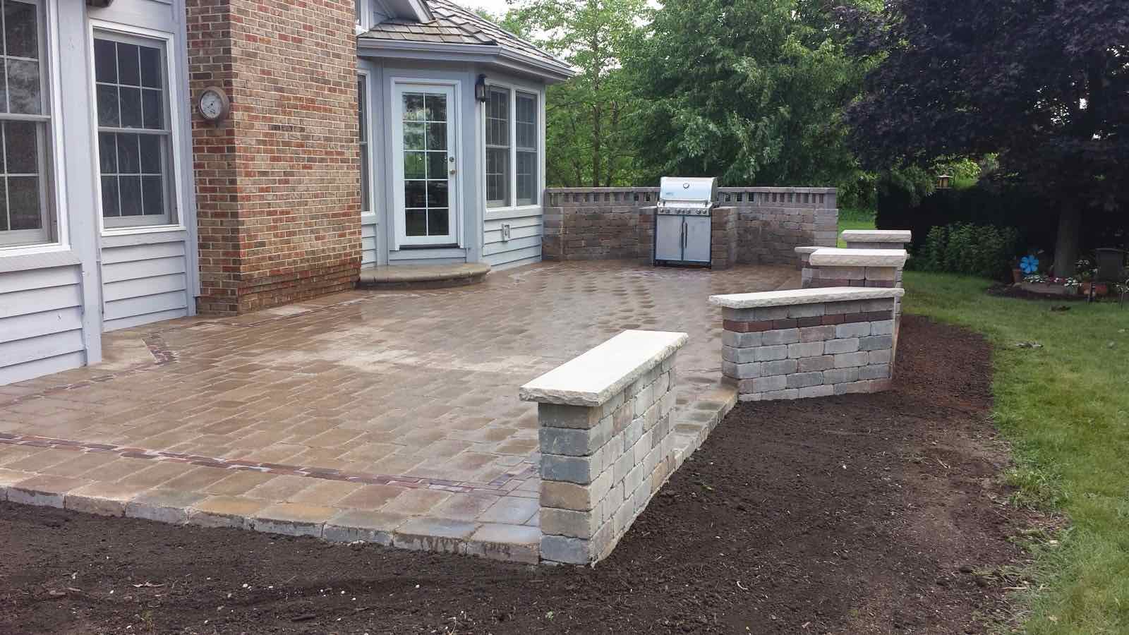 Paver patio with a built-in grill station wall and matching seat walls