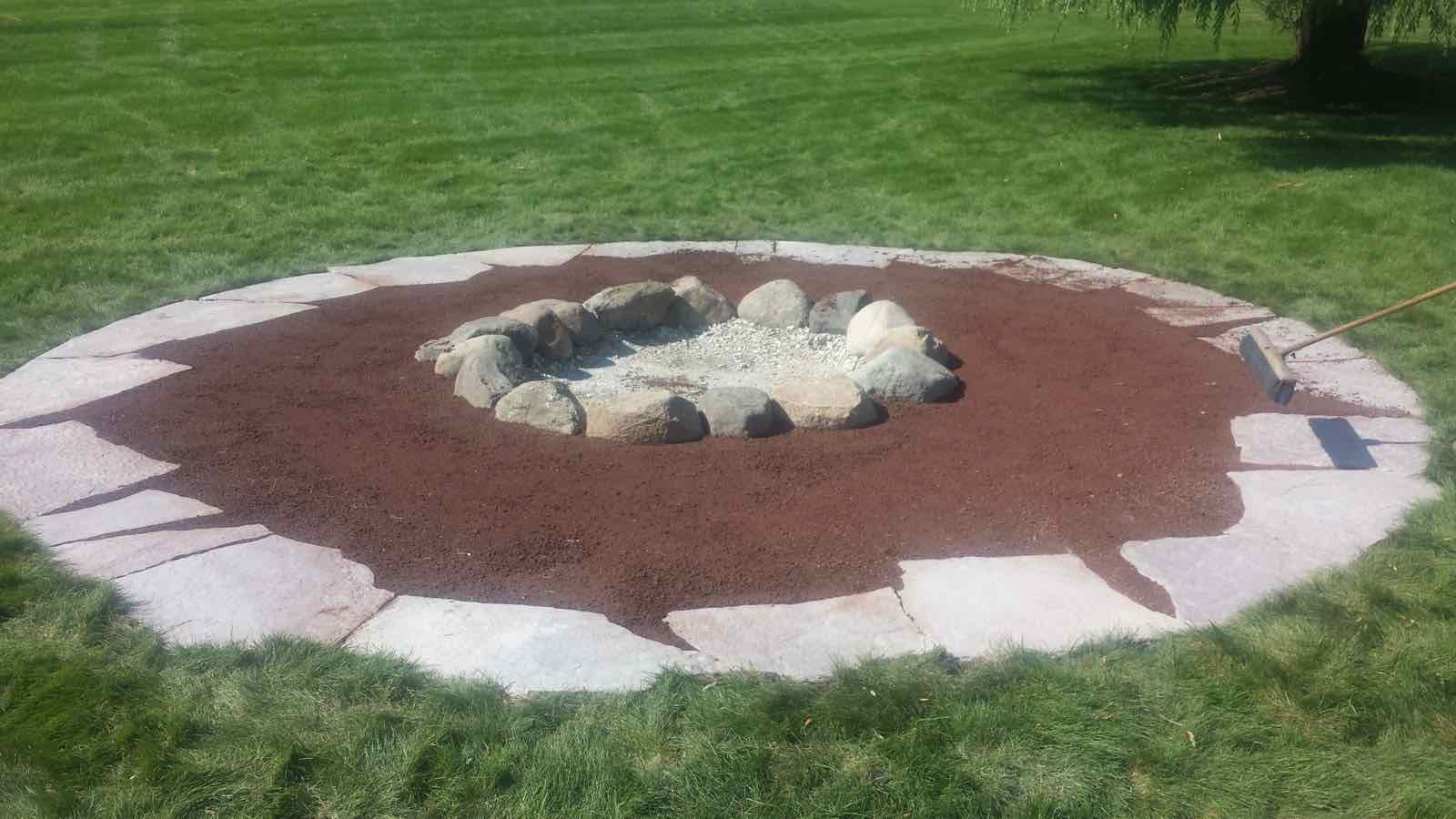 Natural boulder fire pit set into a flagstone patio circle