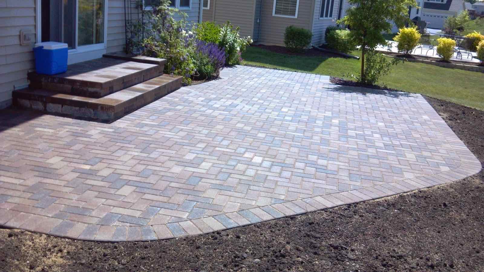 Herringbone paver patio with steps and a fresh planting bed border