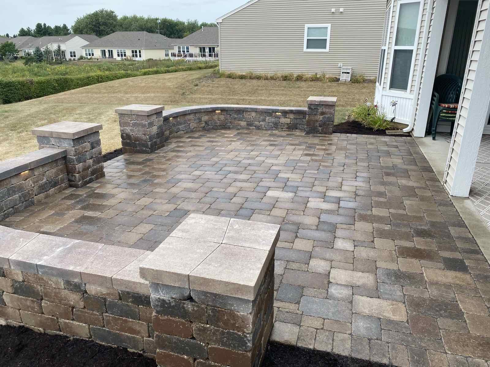 Paver patio with seat walls, lighted pillar caps, and built-in lighting