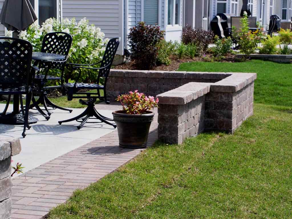 Paver walkway and patio with a low stone seat wall