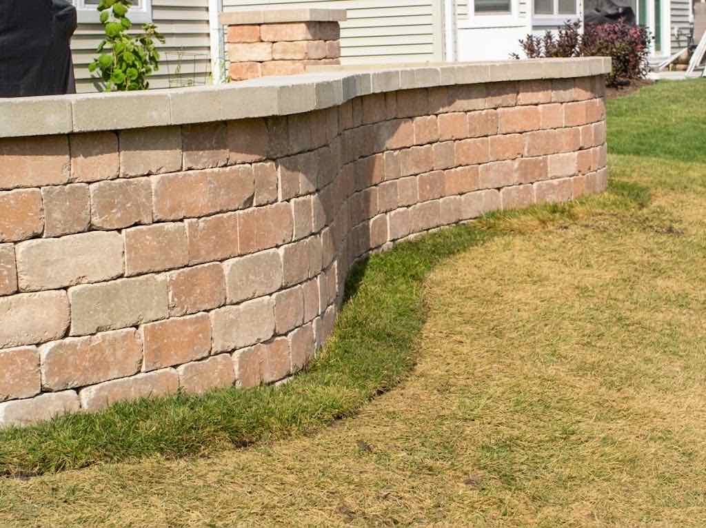 Curved brick seat wall along a backyard patio