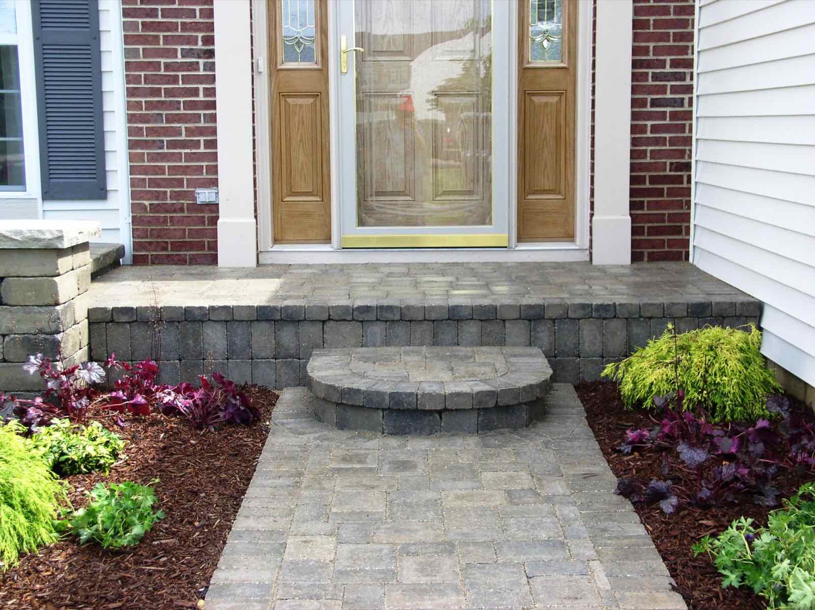 Paver patio and steps leading to a home's front door