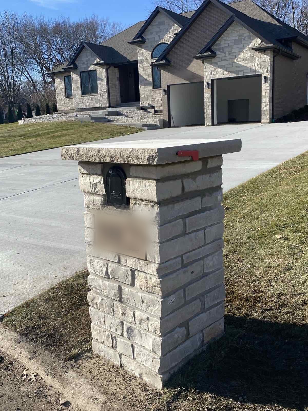 Custom stone mailbox pillar matching a home's stone veneer