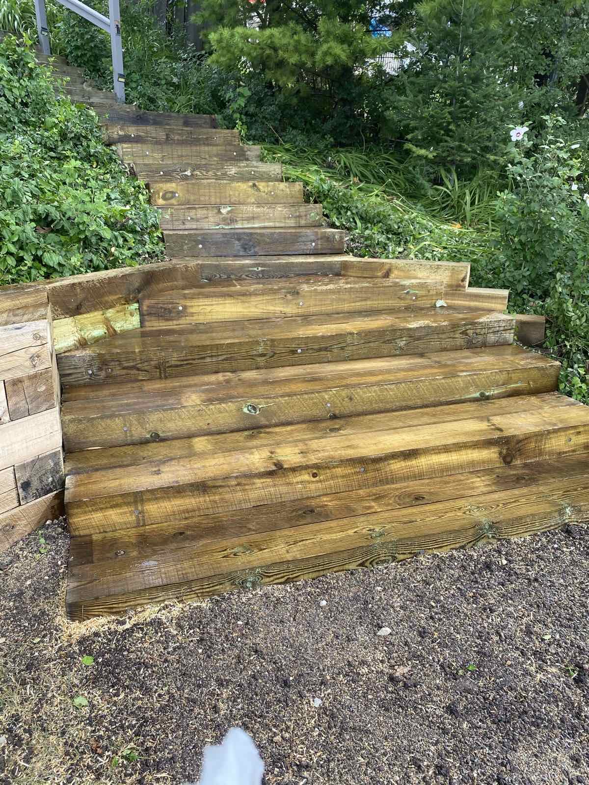 Finished timber staircase with railings set into a sloped yard