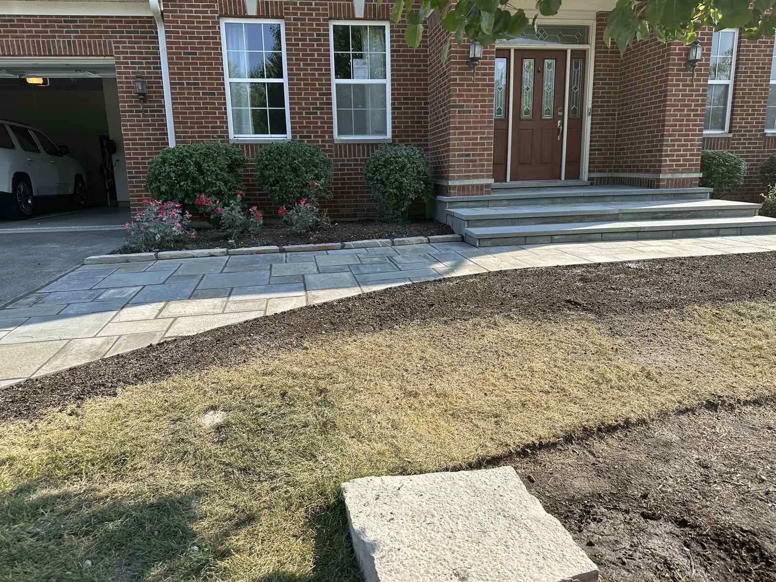 Bluestone entry walkway and steps beside a freshly planted garden bed