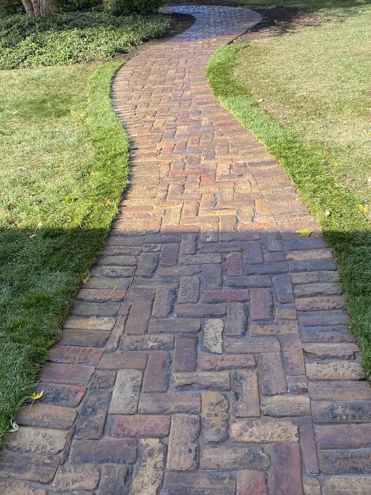 Curved antique brick walkway winding through the front lawn