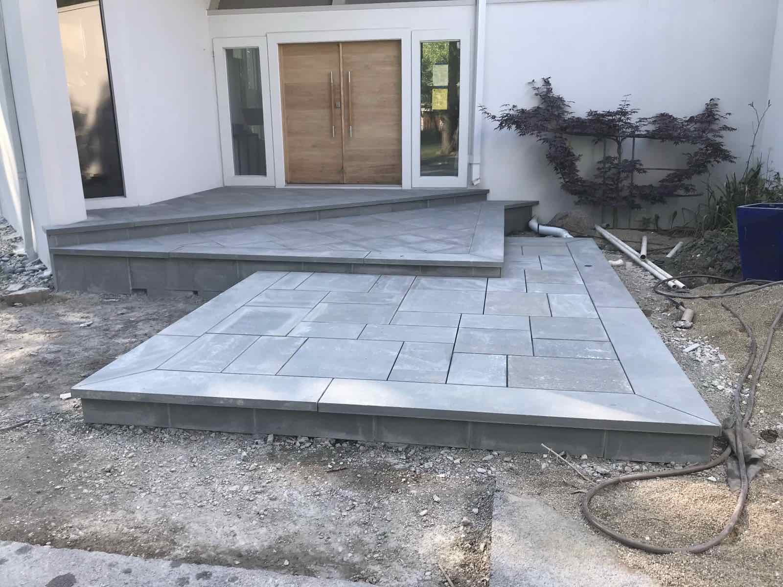 Tiered bluestone entry steps and landing under construction at a modern home